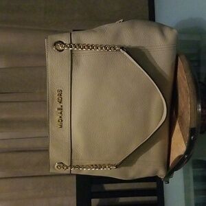 Michael Kors tan pebble leather handbag with leather and gold metal straps.